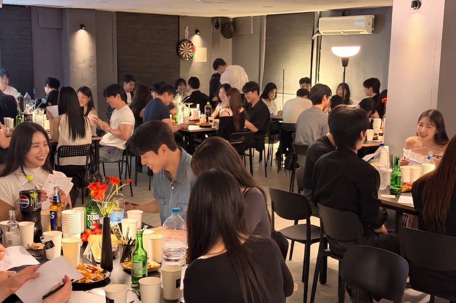 테이블마다 마주 앉아 이야기하는 사람들로 가득 찬 설레임 플레이스 홀